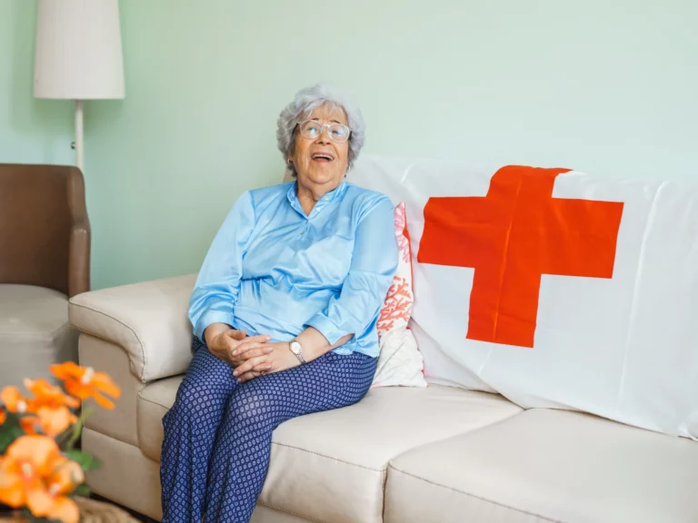 Senhora idosa a sorrir sentada no sofá