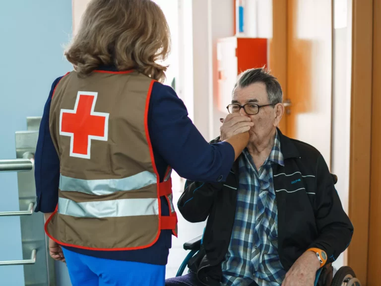 Voluntária da Cruz Vermelha Portuguesa a apoiar idoso