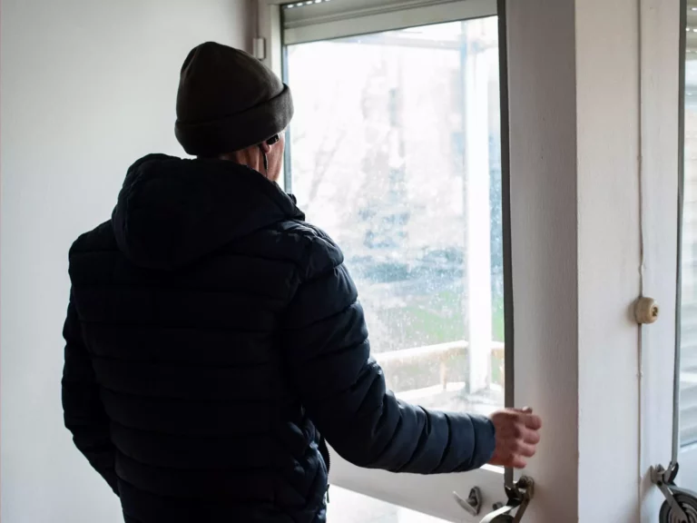 Homem de gorro a olhar pela janela